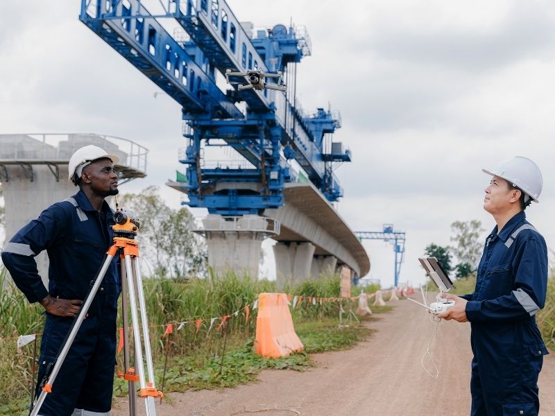 Engineers inspecting a bridge construction project, illustrating the role of elastomeric bridge bearings in supporting movement and load transfer